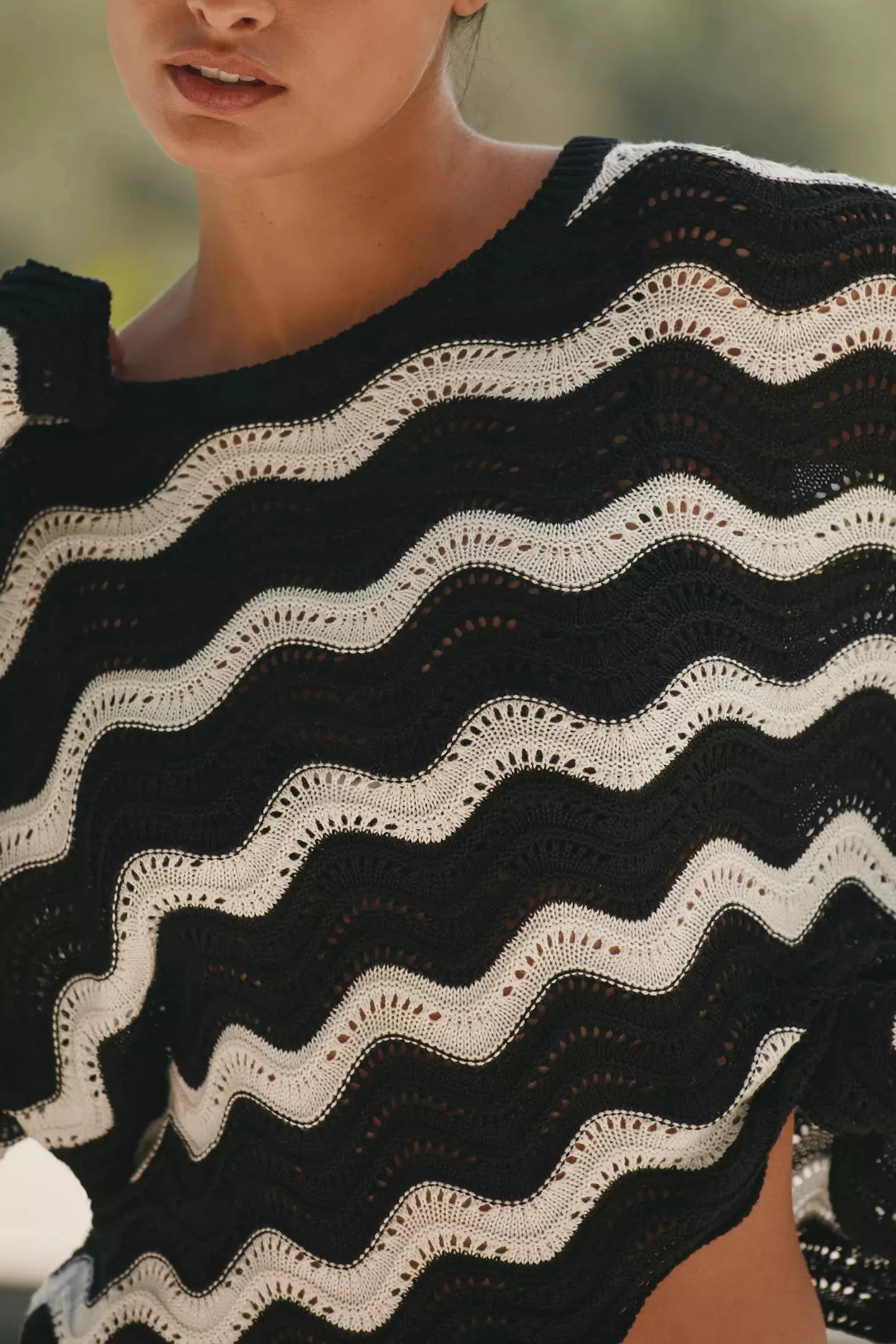 Black and white patterned cover up worn by a person with a blurred background
