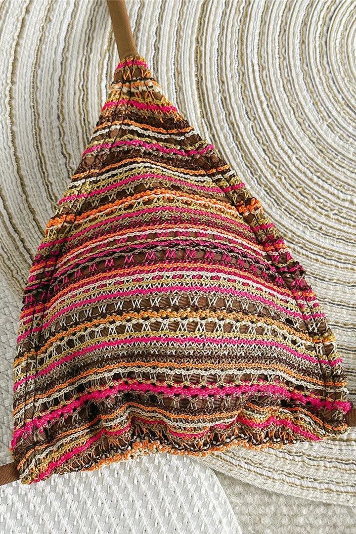 Colorful striped bikini top against a textured beige background