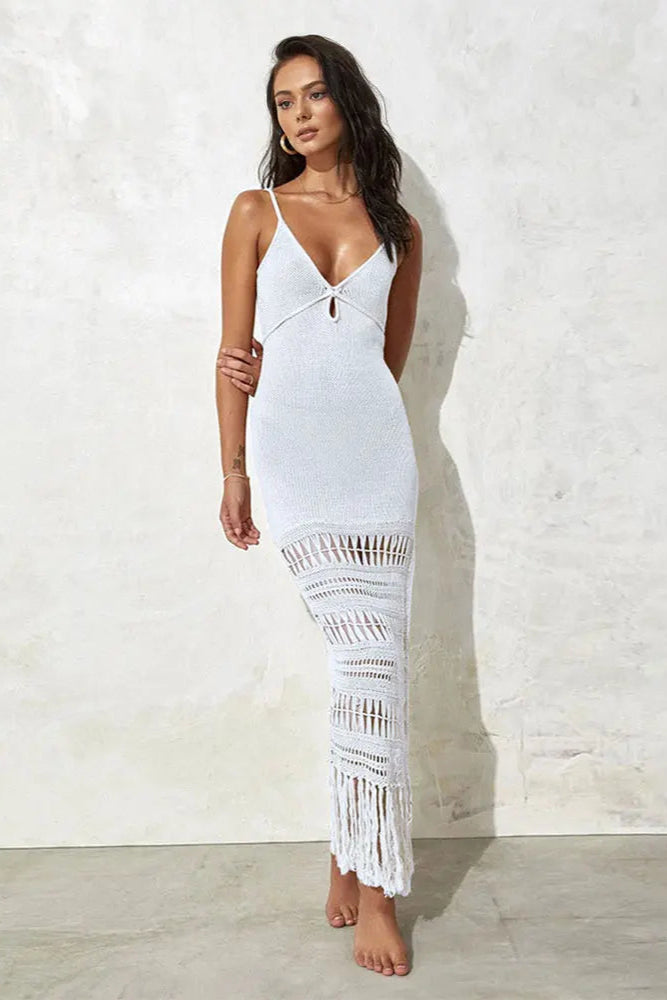 Woman wearing a white dress with a crochet hem against a light background