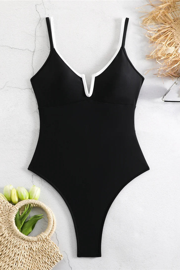 A black one-piece swimsuit with thin shoulder straps and a split V-neckline outlined in white