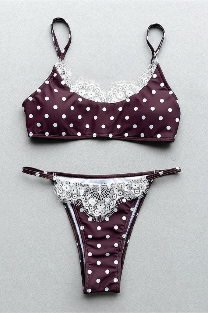 A two-piece women's bikini set laid flat on a light gray background. The set features a deep brown color with white polka dots and white lace trim on the bra and thong.