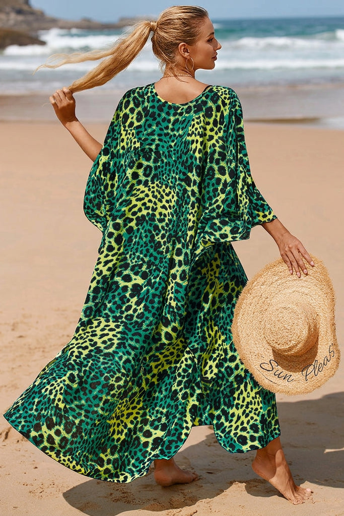 A woman wearing a loose, long-sleeve maxi dress with a green and yellow leopard print.