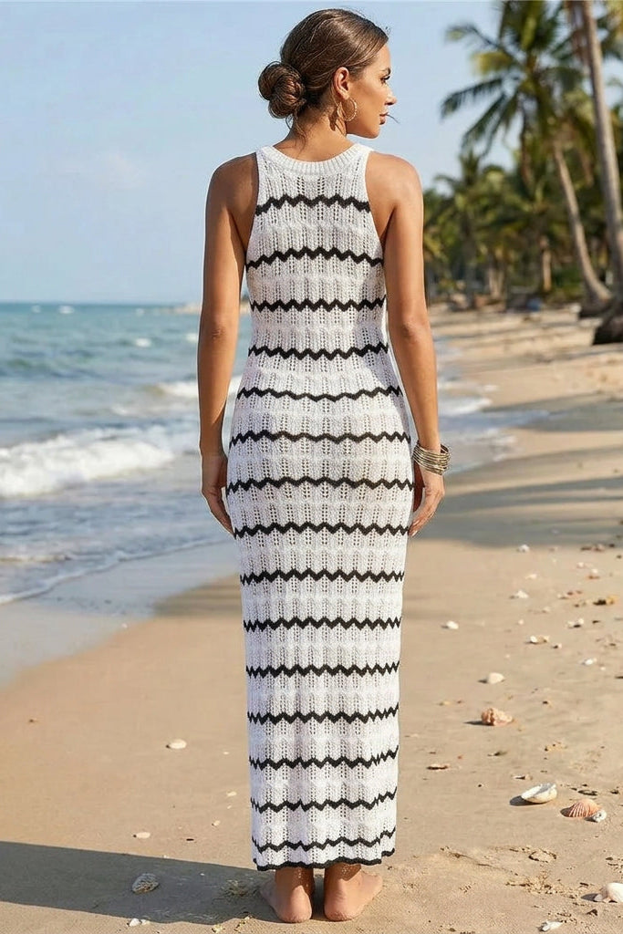 A woman wearing a sleeveless white knit maxi dress with black wavy horizontal stripes.
