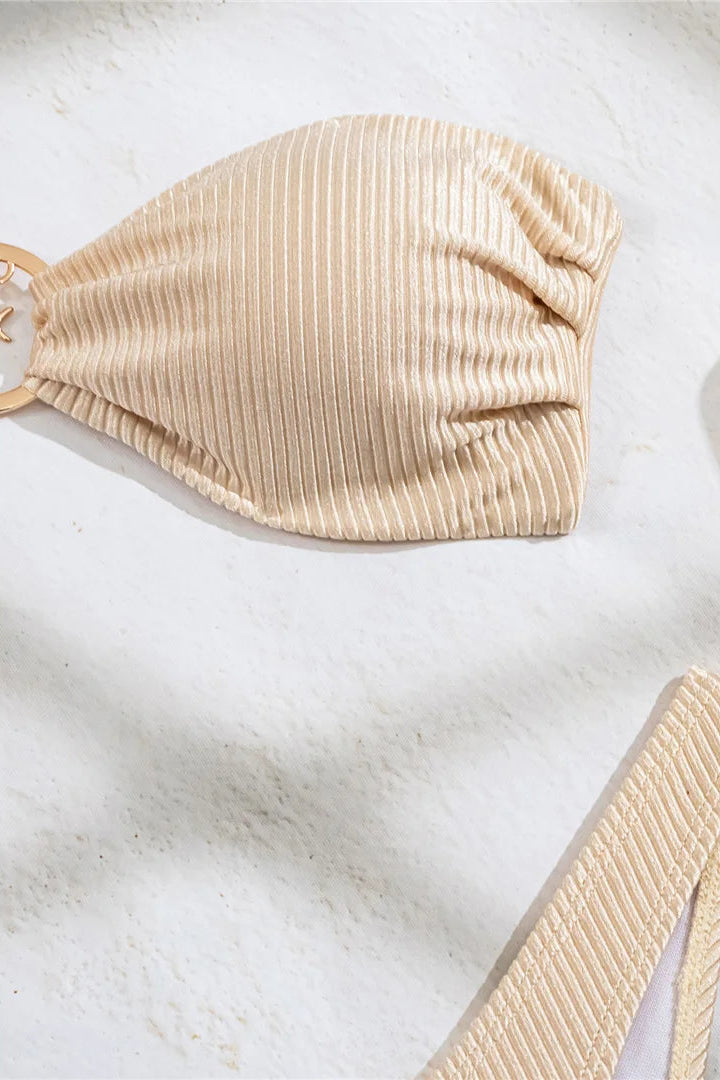 Beige bikini top on a white marble surface