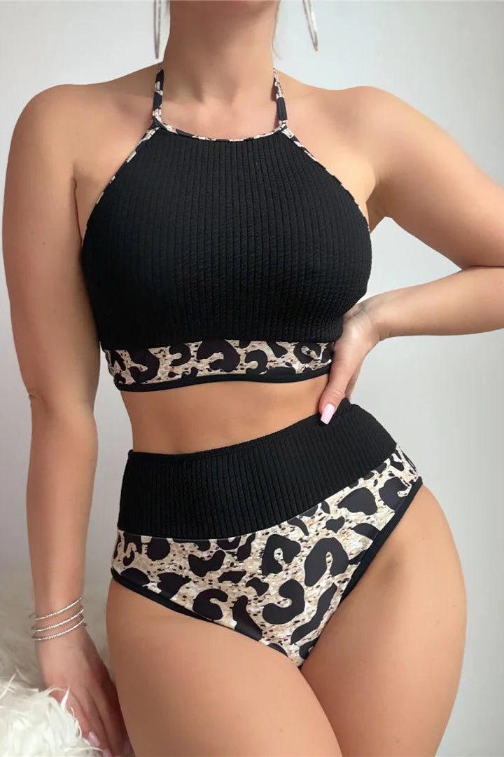 Black and leopard print bikini set on a plain background