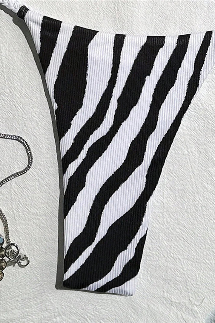 Black and white zebra-striped bikini bottom on a textured white background