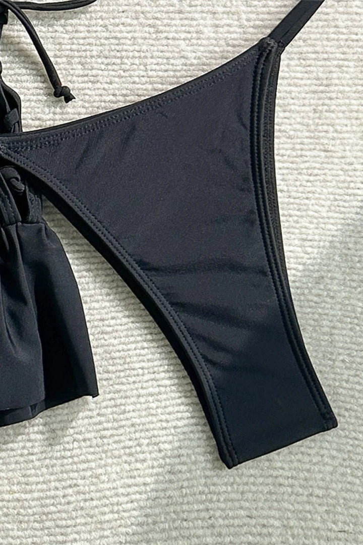 Black bikini bottom on a textured surface