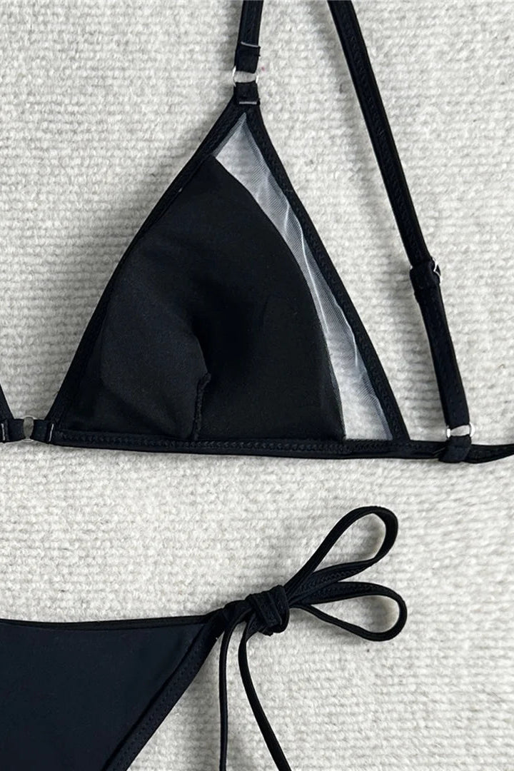 Black bikini set on a textured white surface