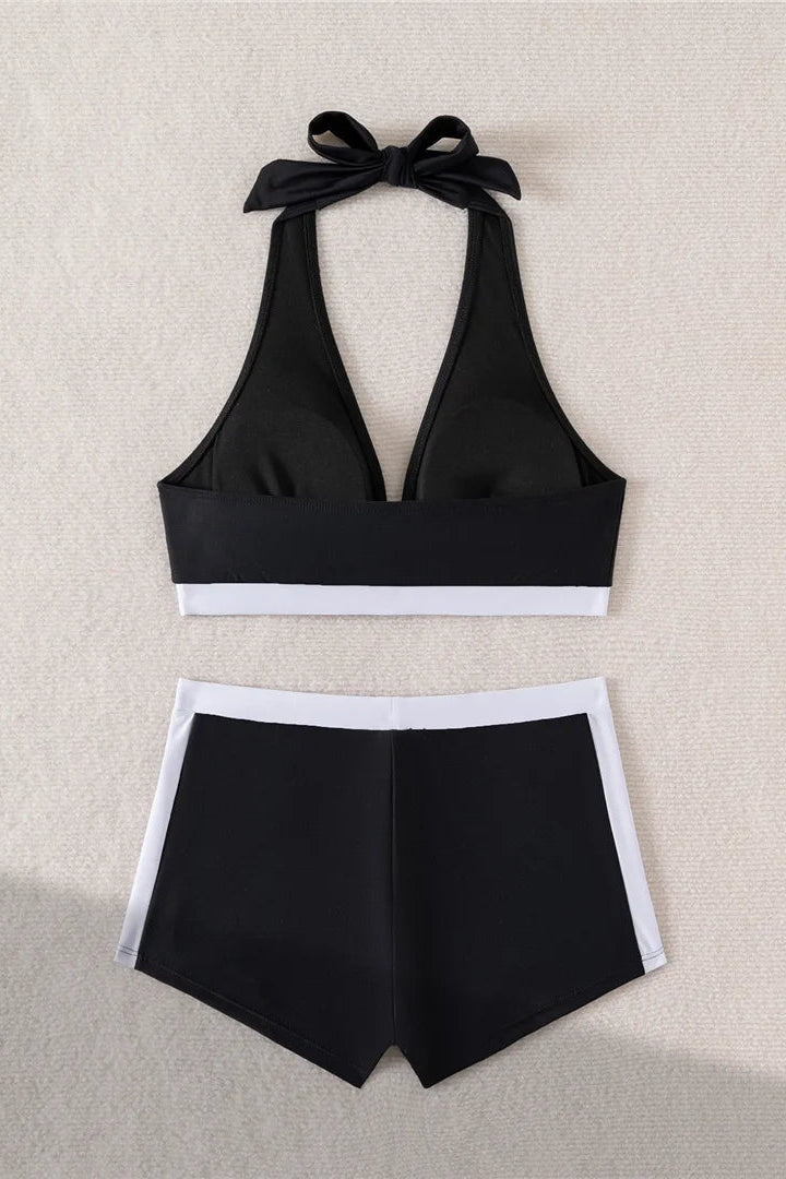 Black bikini set with a halter top and shorts on a beige background