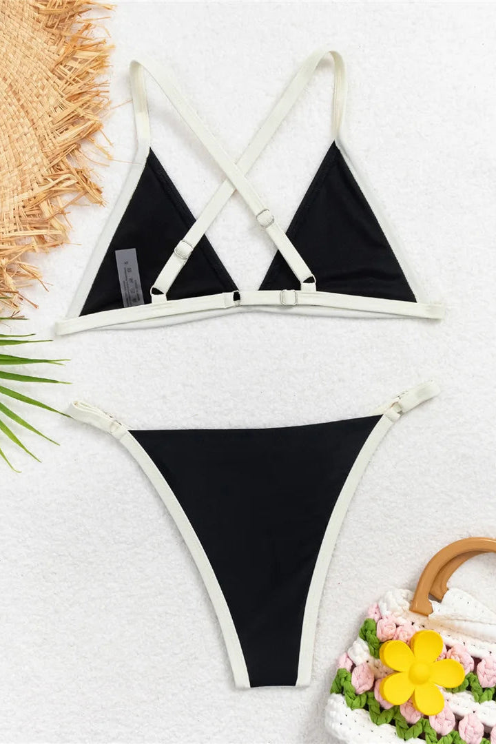 Black bikini set with white cross back straps on a light gray background