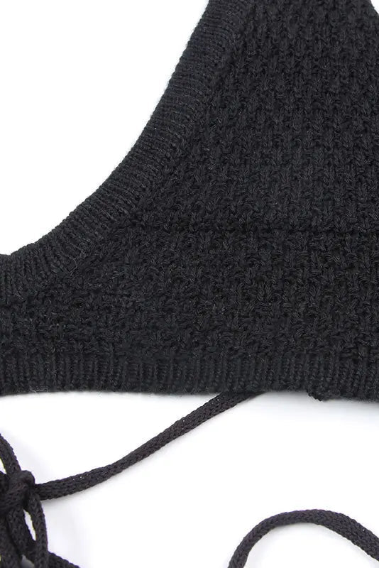 Black knitted bikini top on a white background