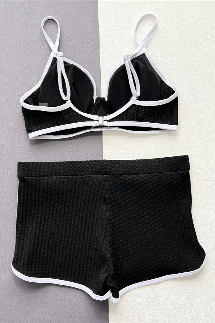 Black ribbed bikini set with white trim on a gray and white background