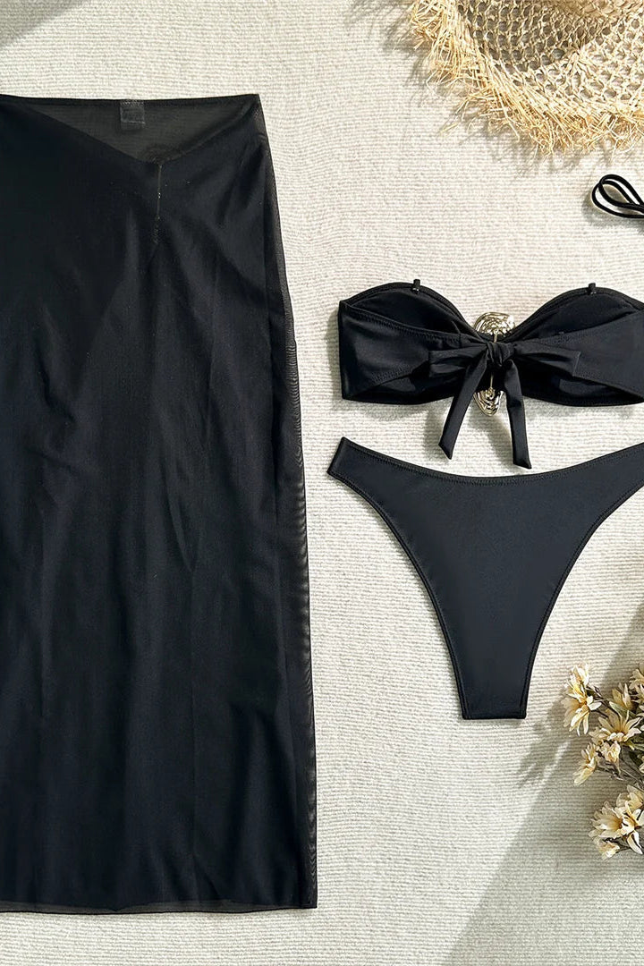 Black skirt and bikini set on a textured surface