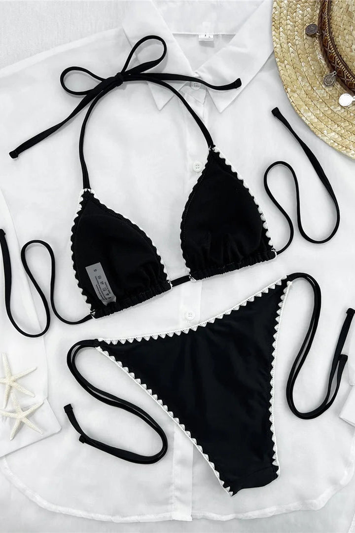 Black string bikini set with white scalloped trim, laid flat