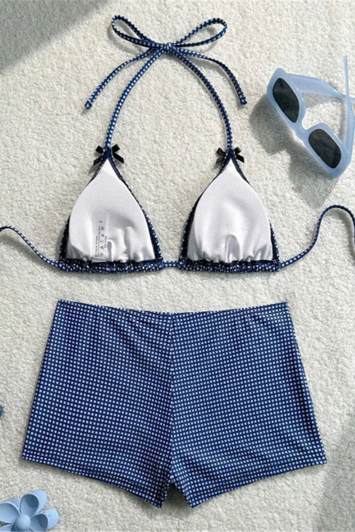 Blue and white bikini set with matching shorts on a textured surface.