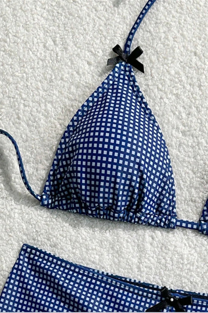 Blue and white checkered bikini set on a textured white background