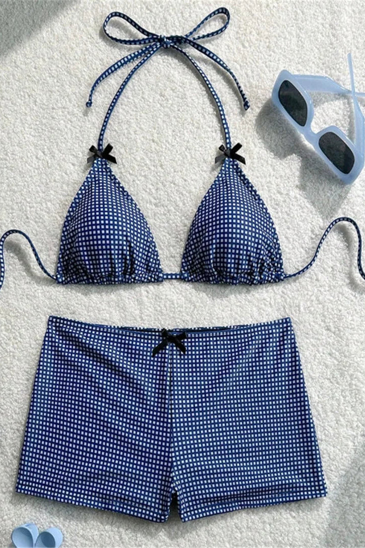 Blue patterned bikini set with matching shorts on a textured surface.