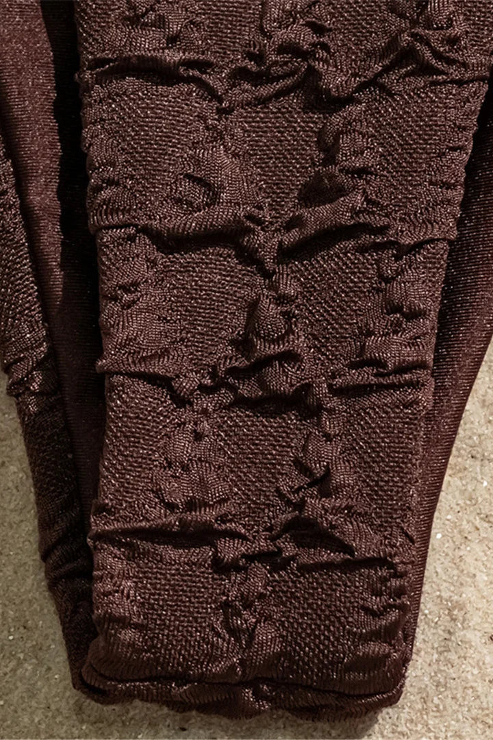 Brown bikini bottom textured fabric on a beige surface