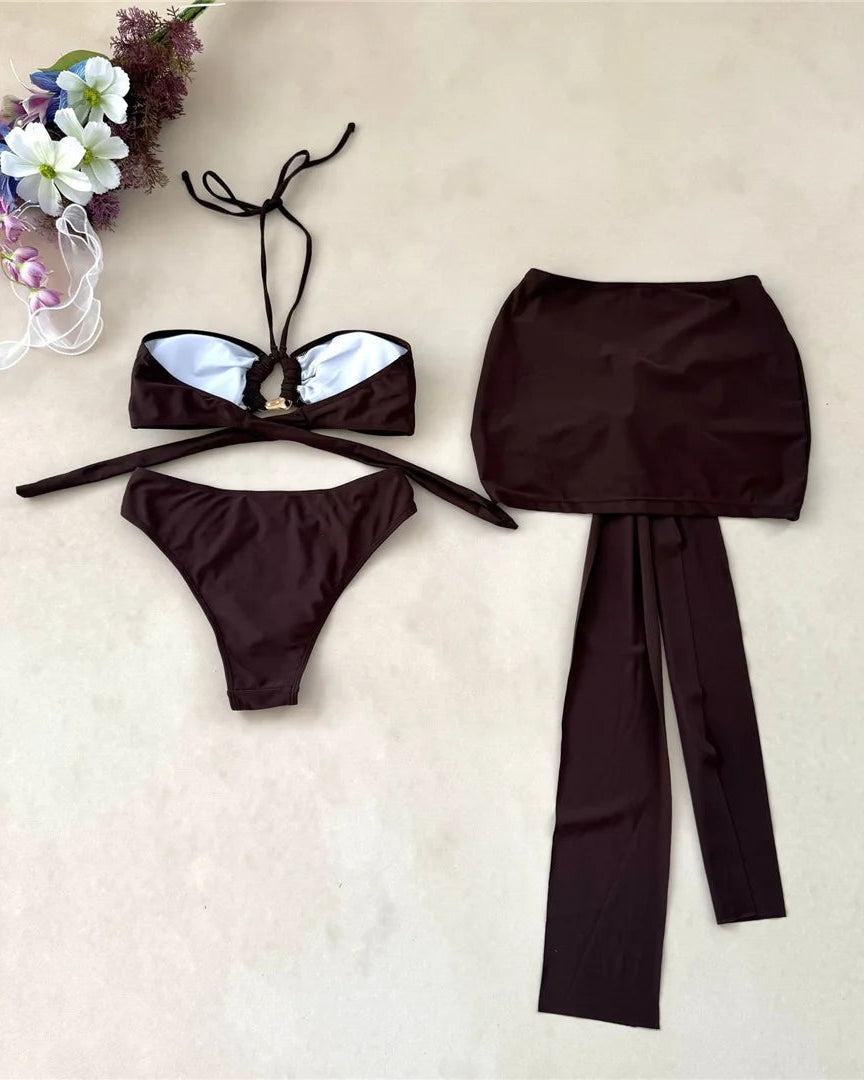 Brown bikini set with matching skirt on a beige background