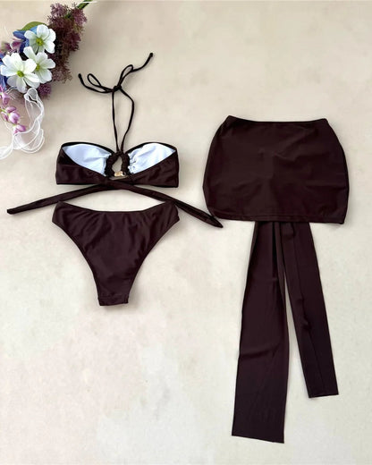 Brown bikini set with matching skirt on a beige background