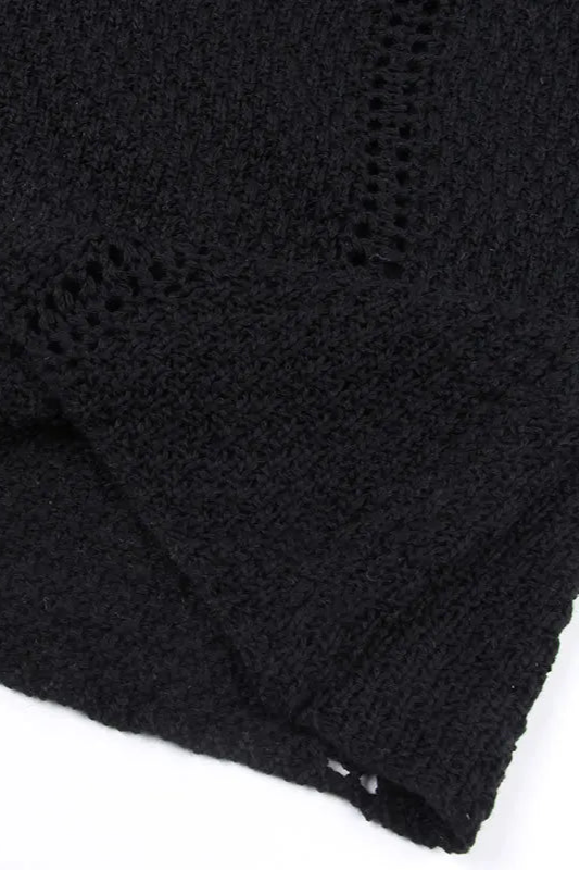 Close-up of a black knitted fabric with a textured pattern on a white background