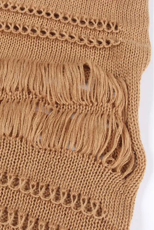 Close-up of a brown knitted fabric with fringe details on a white background