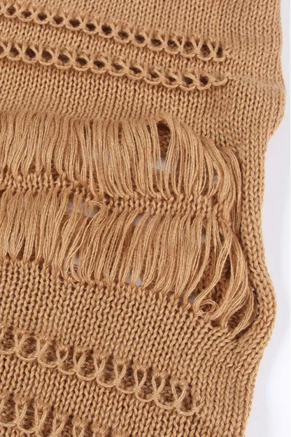 Close-up of a brown knitted fabric with fringe details on a white background