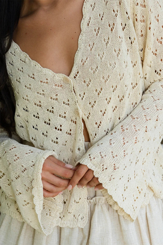 Close-up of a person wearing a cream-colored lace dress with a blurred background