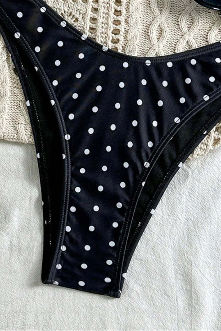 Close up of White polka dots on black bandeau bikini bottom for women