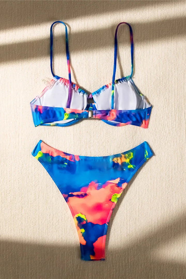 Colorful bikini set on a beige surface