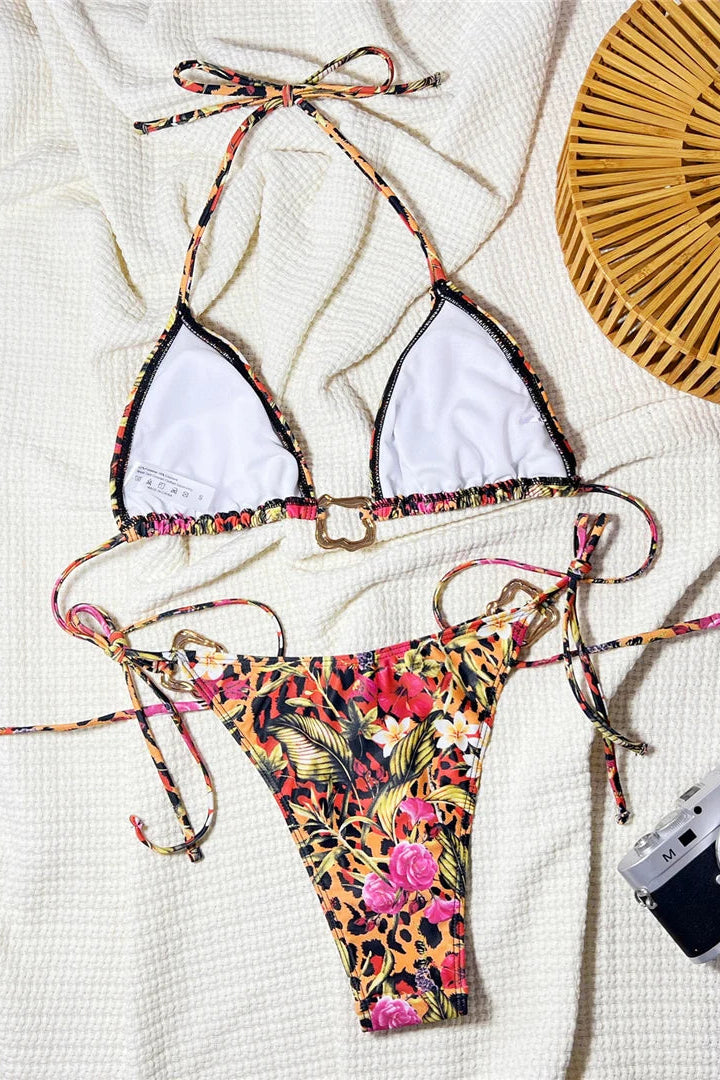 Colorful bikini set with floral and leopard print design on a white surface.