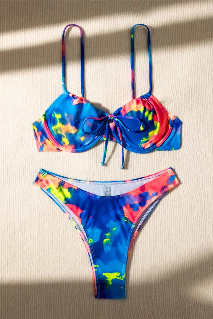Colorful tie-dye bikini set on a textured surface