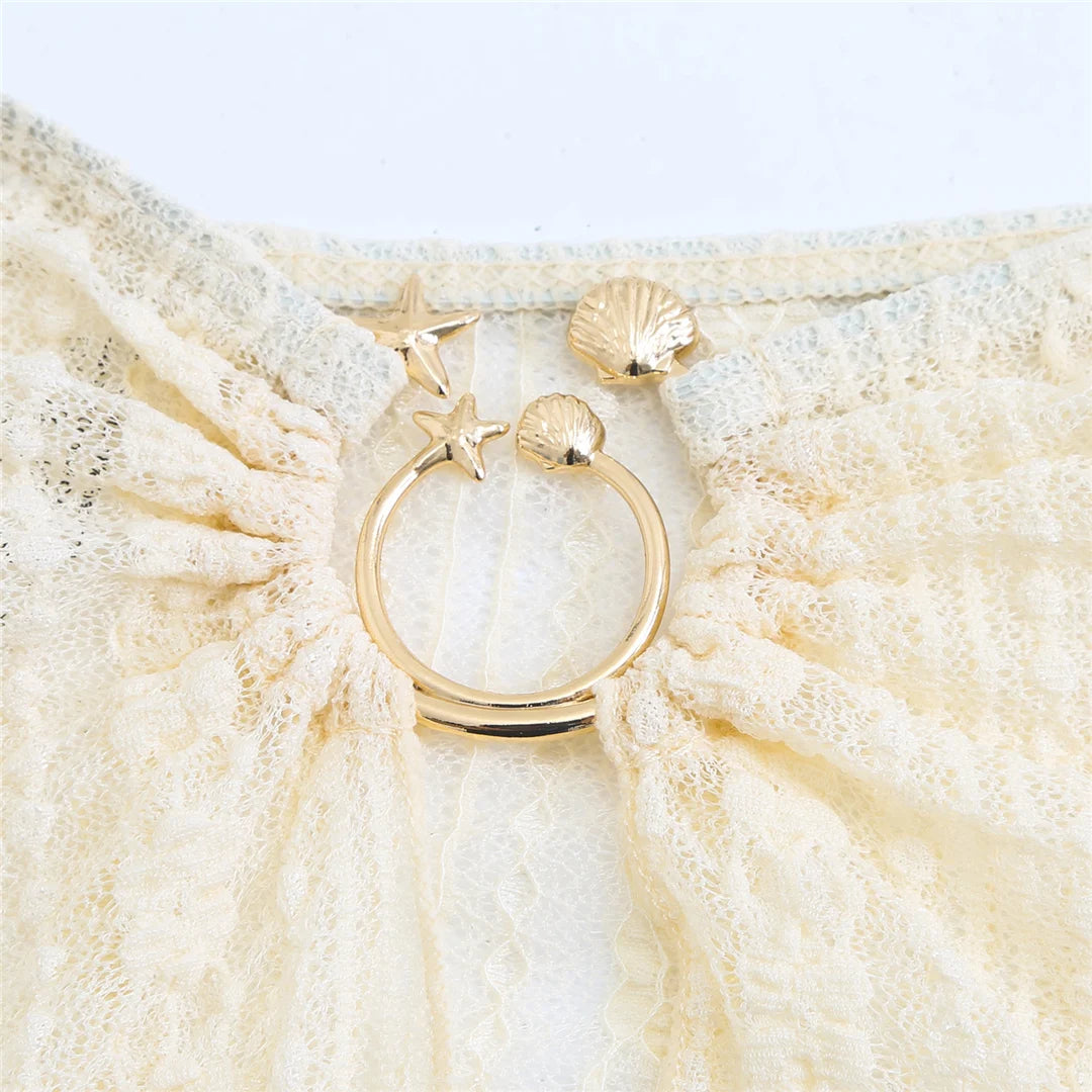 Gold ring with star and shell design on a cover up skirt