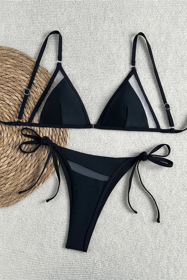 High-cut, low-rise bikini bottoms with lace-up details elongate the legs and create a flattering silhouette.