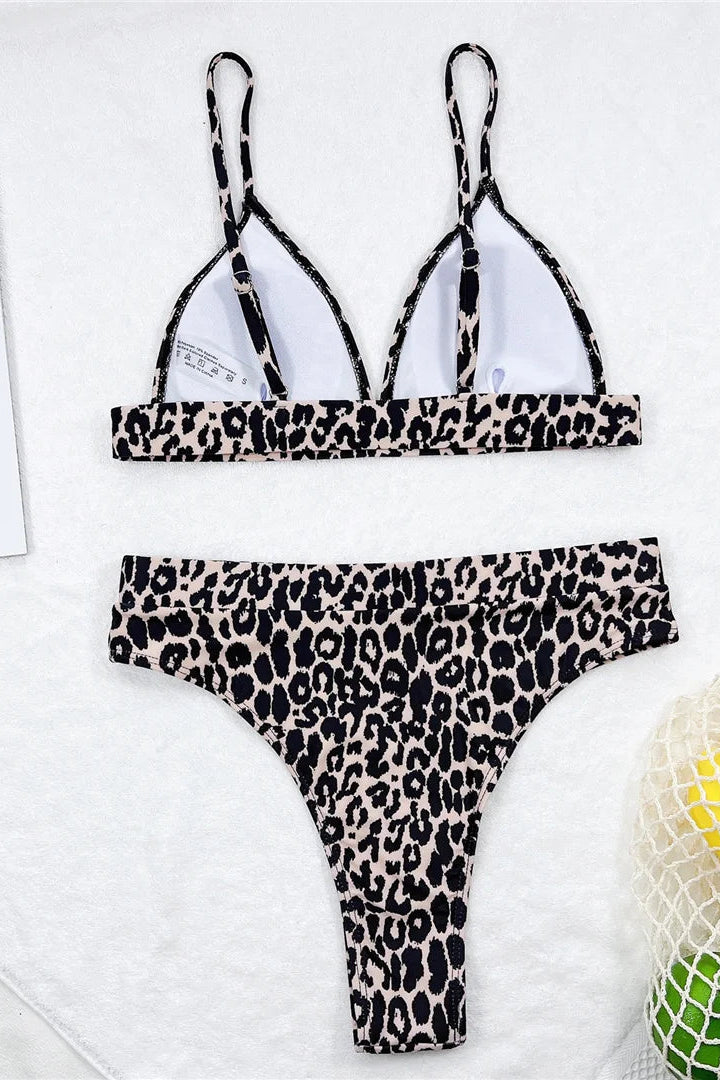 Leopard print bikini set on a white surface with a magazine in the background
