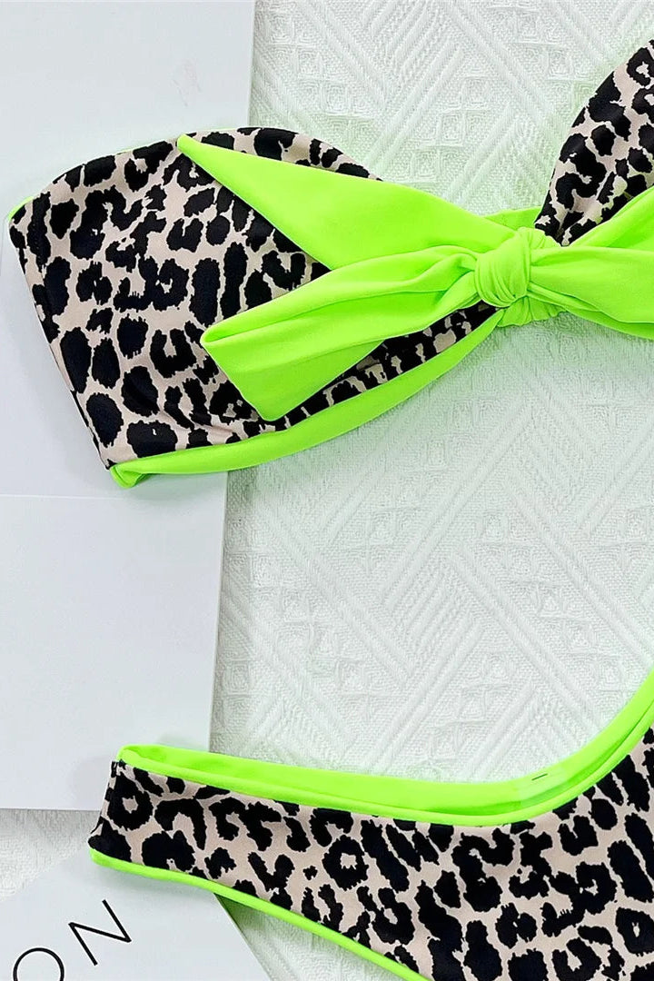 Leopard print bikini with green trim on a white surface