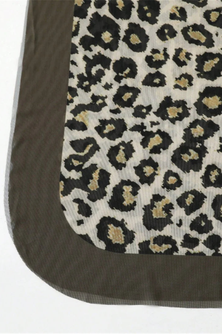 Leopard print pattern on a textured surface with a brown border.
