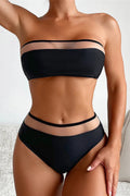 Person wearing a black bikini set on a neutral background
