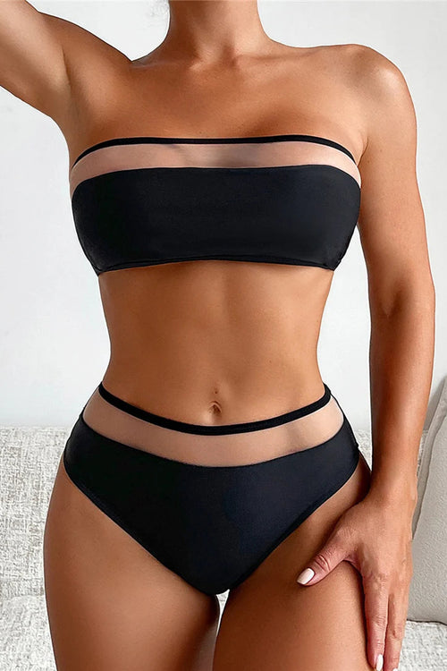 Person wearing a black bikini set on a neutral background