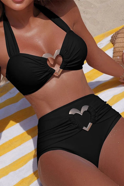 Person wearing a black bikini with a brand logo on a striped towel