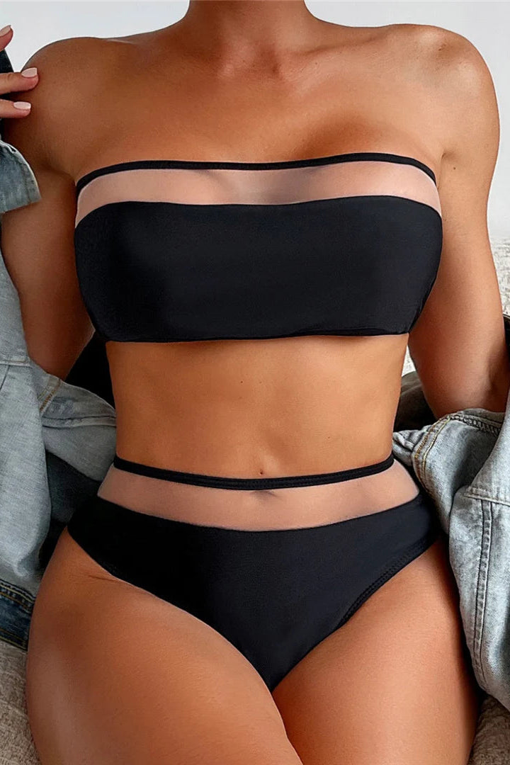 Person wearing a black bikini with a denim jacket over shoulders