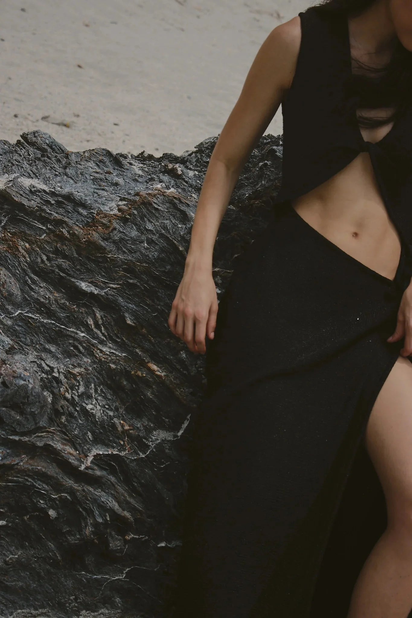 Person wearing a black outfit standing on a rocky surface