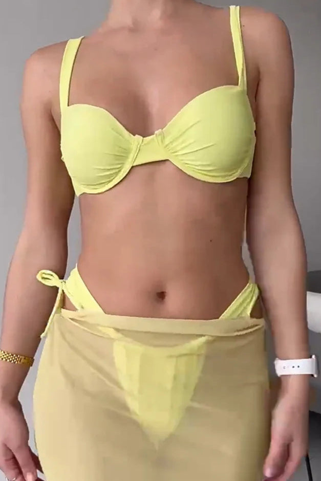 Person wearing a yellow bikini set with a plain background