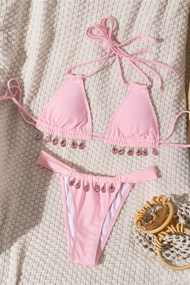 Pink bikini set with decorative elements on a textured surface