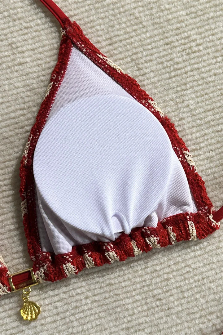 Red and white padded bikini top with gold accents .