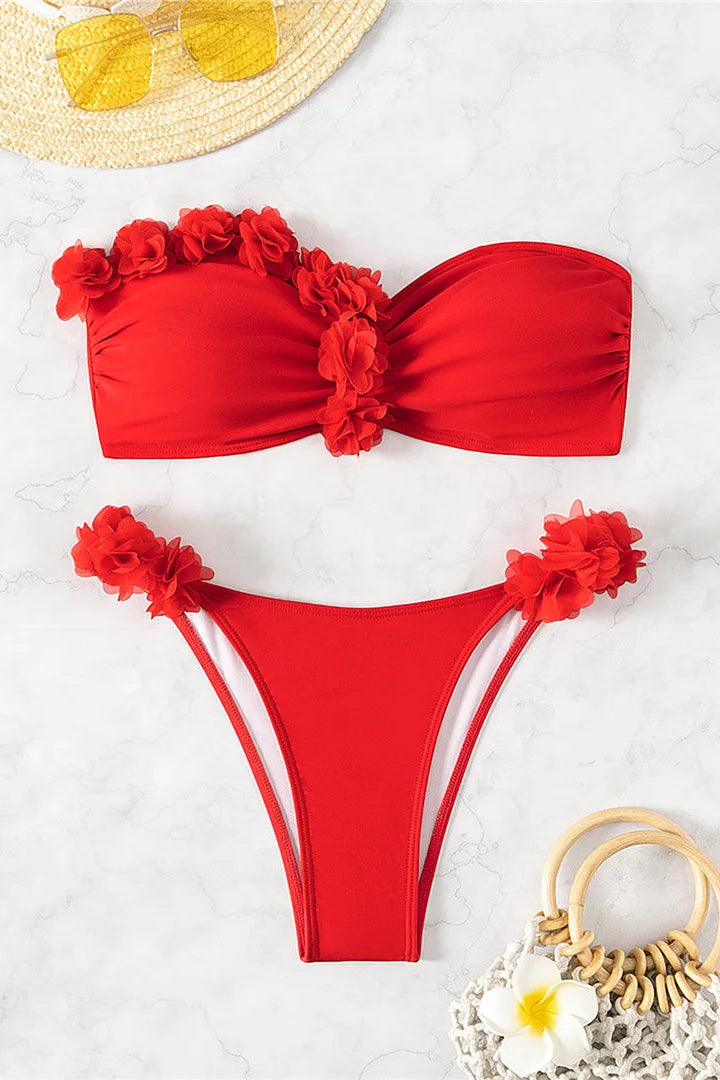 Red bikini set with floral details on a light gray background