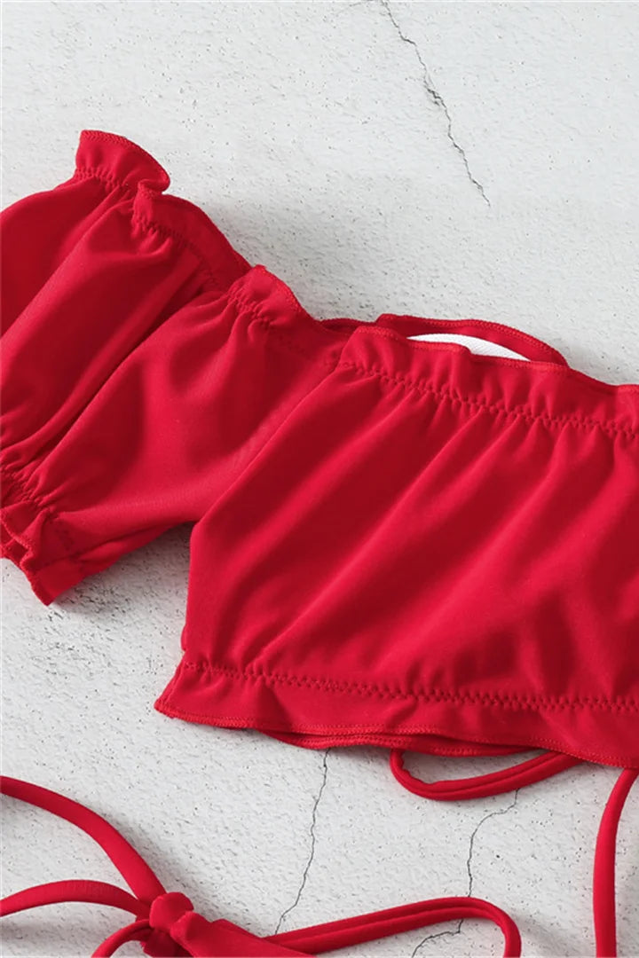 Red bikini top on a textured white background