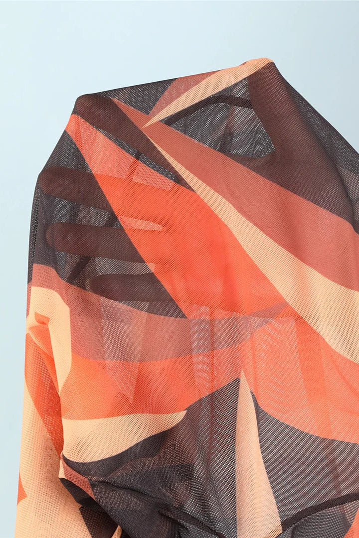 Sheer fabric with orange, black, and beige pattern on a light blue background