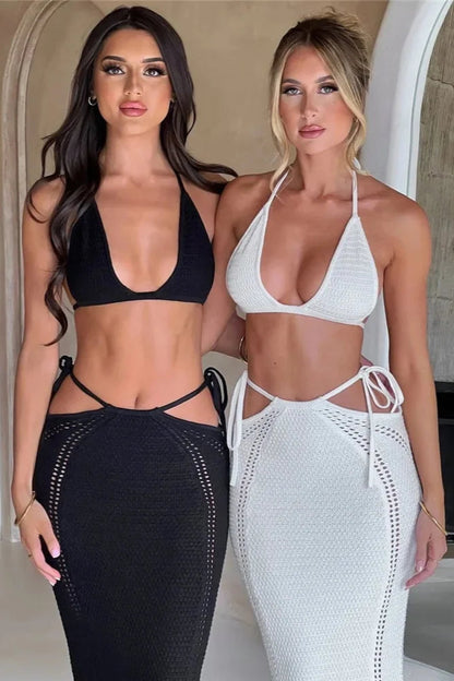 Two women in black and white beach wear standing side by side.