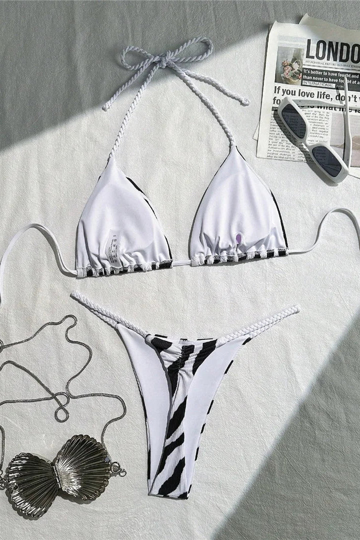 White and black striped bikini set on a light surface
